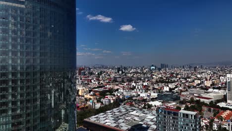 aerial view near the mitikah building, overlooking the cityscape of sunny benito juarez, mexico city - ascending, drone shot