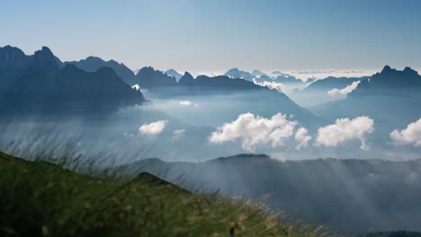 lapso de tiempo de un paisaje montañoso profundo y algo de niebla y nubes creando rayos de sol en la mañana