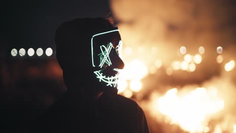 persona con una máscara brillante por la noche