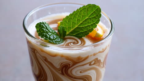 delicious swirled coffee drink with mint and orange garnish