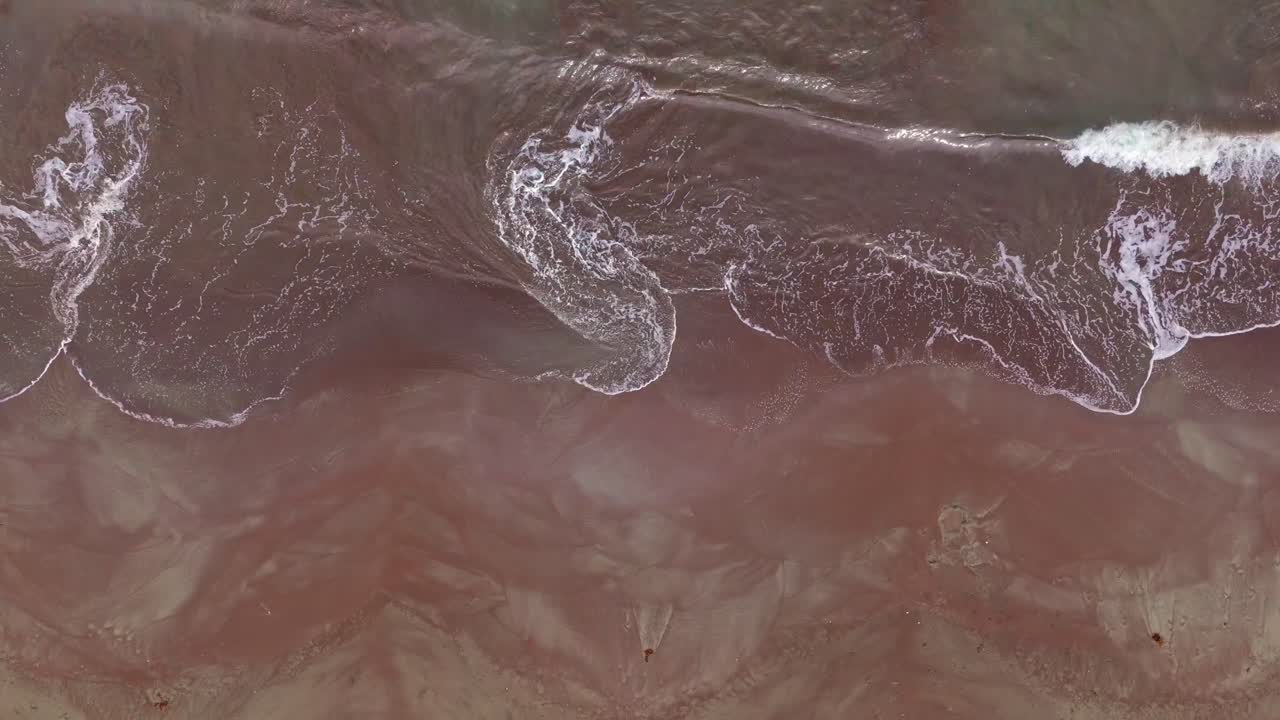 Beautiful shallow swirling waves on a sandy orange and brown sandbar or shoal