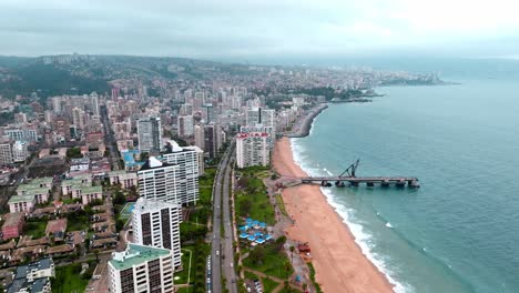 Dolly-in-aerial-view-of-El-Sol-beach-and-Vergara-Pier-in-ViÃ±a-del-Mar,-Chile