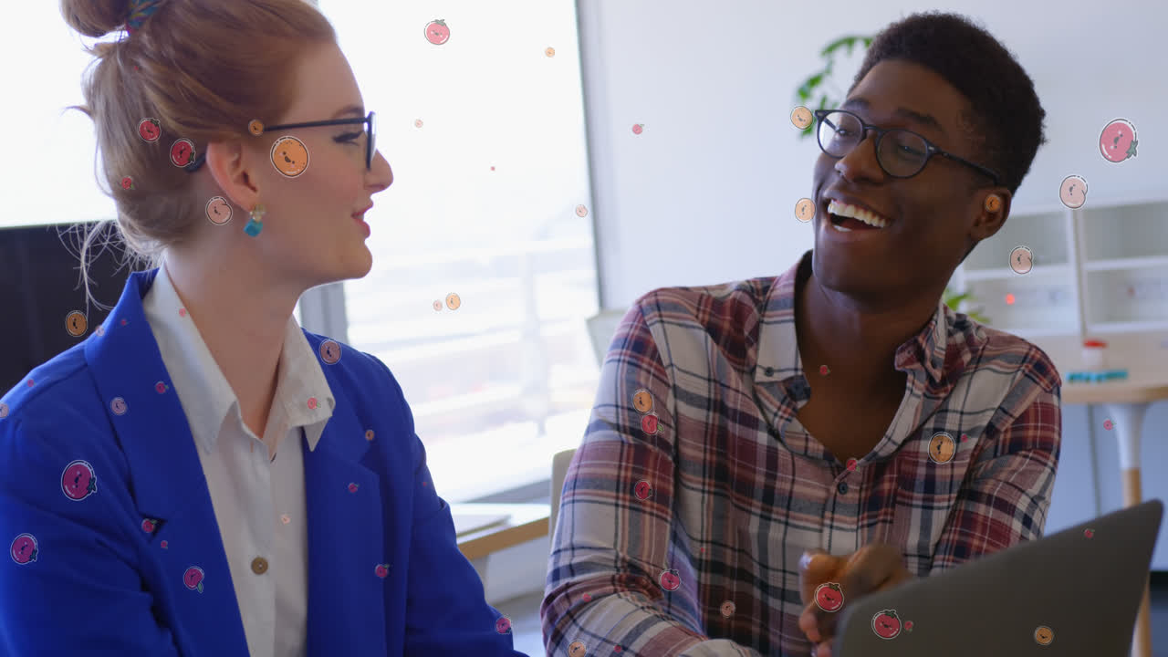 Animation of fruit icons over diverse business people talking