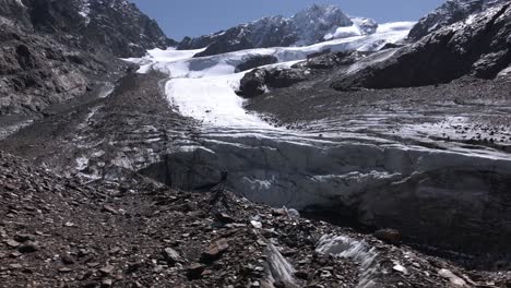 el hombre está parado frente a una lengua glaciar en los alpes italianos