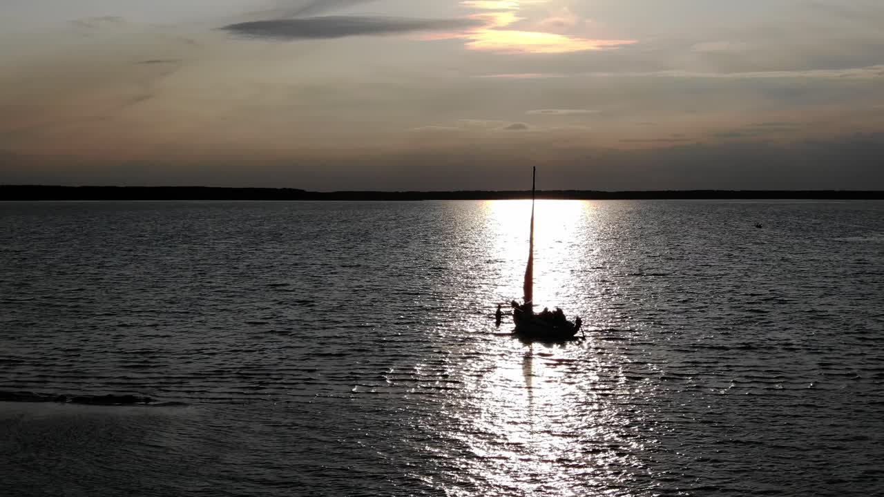 Un gruppo di amici in procinto di gettare l'ancora durante un tramonto