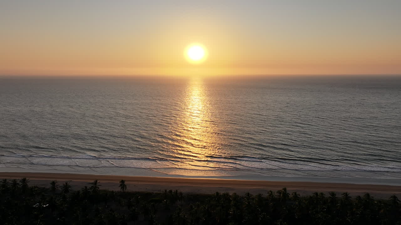 A beautiful sunset over a peaceful beach, capturing the warm light reflecting on the water
