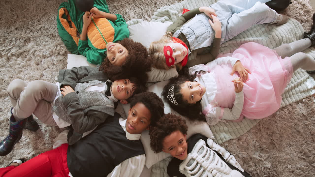 Group of Children in Costumes Lying on Carpet