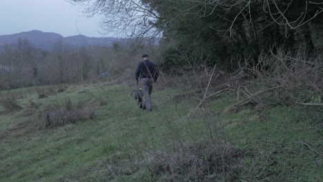 Man-carrying-chopped-logs-in-wheelbarrow