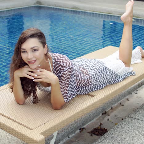 happy woman relaxing on lounger on poolside