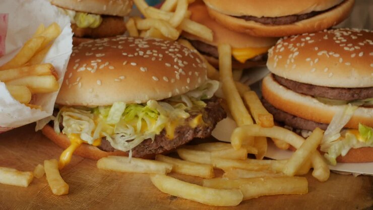 portion of unhealthy food, fast food, stack of burgers, fries rotating, turning