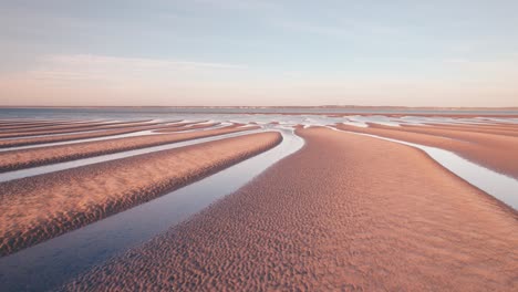hermosas dunas de arena naranja dorada con líneas principales hacia el horizonte del océano