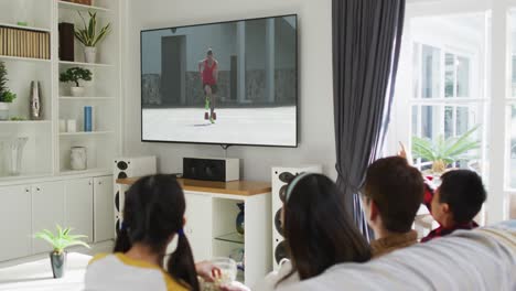 Composite-of-happy-family-sitting-at-home-together-watching-athletics-running-event-on-tv