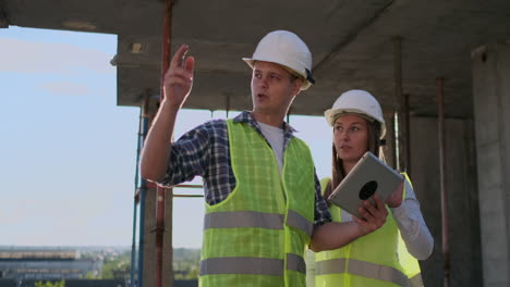 equipo de construcción o arquitecto y constructor o trabajador con cascos discuten un plan de construcción de andamios o un plan o una lista de comprobación