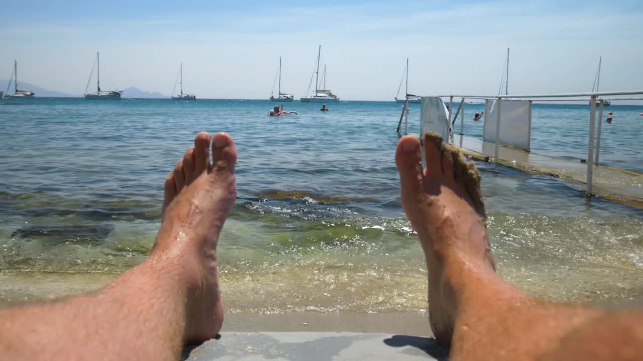 Person Relaxing On The Beach Of Kardamena Resort Town In Kos Island, Greece. Close-up Shot