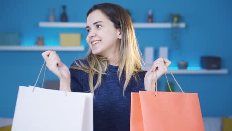 una joven a la que le encanta ir de compras muestra sus bolsas de compras a la cámara.