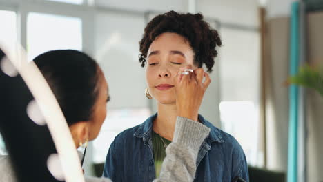 artista de maquillaje aplicando maquillaje a una mujer