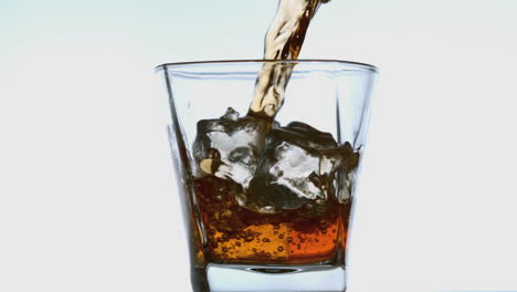 Whiskey-pouring-into-tumbler-with-ice