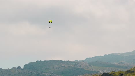 paragliding high above a mountain range on a cloudy day in merlo, san luis, argentina