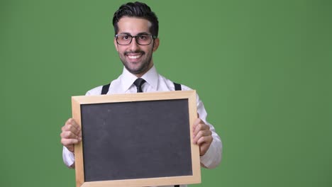 joven empresario persa barbudo y guapo contra un fondo verde