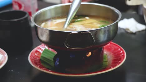 serving traditional thai hot pot soup at restaurant in phuket