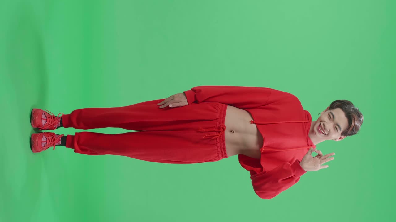 Full Body Of A Portrait Of A Happy Asian Transgender Male Showing Okay Gesture To The Camera In The Green Screen Studio