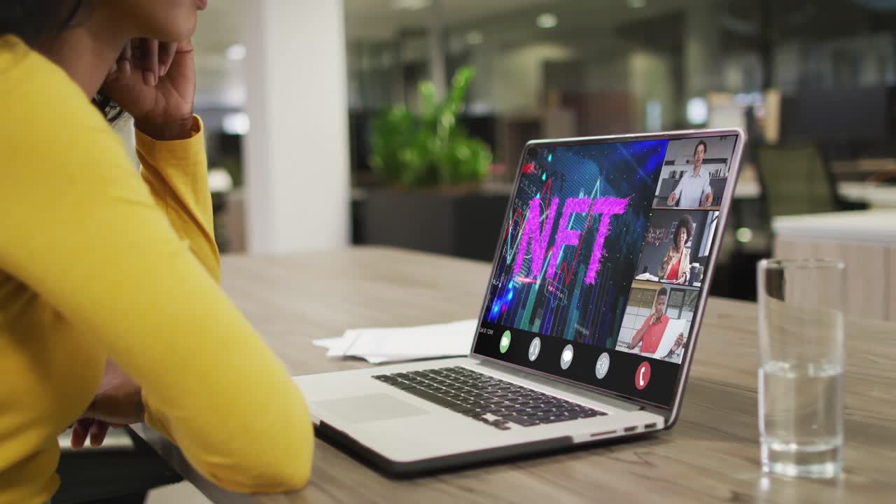 Empresária birracial usando notebook para videochamada com diversos colegas de negócios