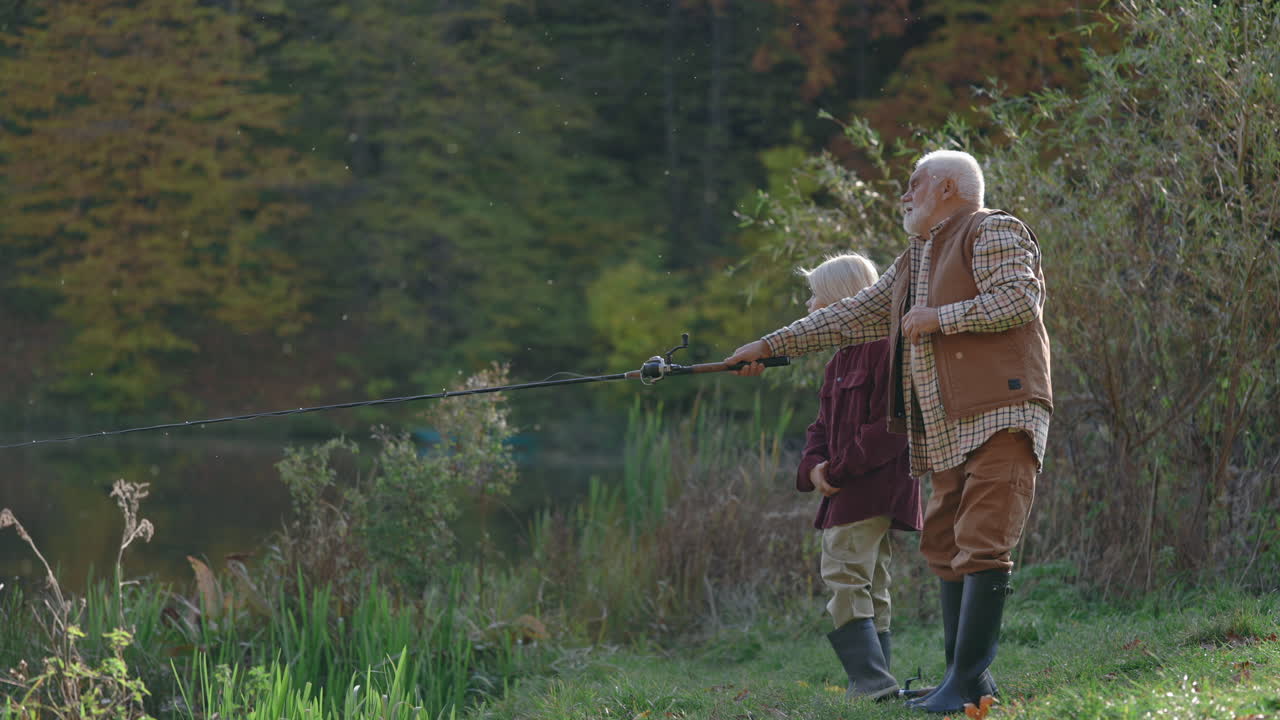 Grandfather and Grandchild Fishing by a Lake in Autumn
