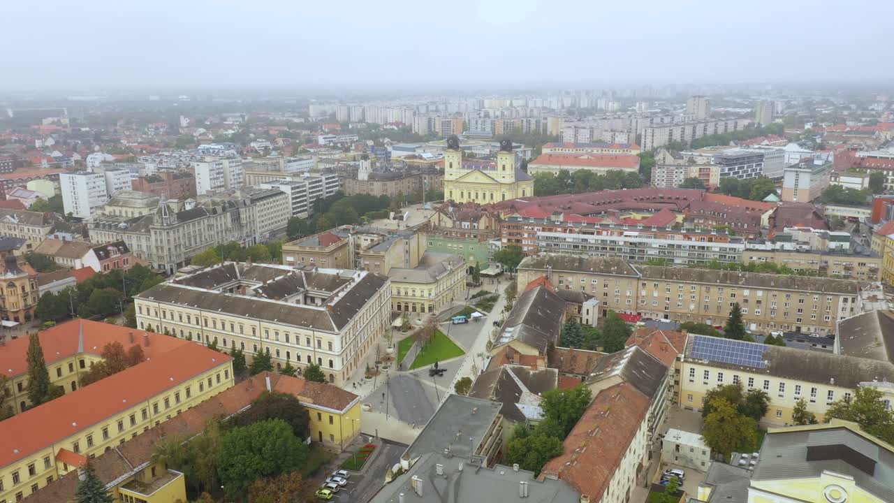 imágenes de drones de la iglesia en la plaza principal de la ciudad de debrecen en clima lluvioso de otoño. el dron vuela rápido hacia atrás y hacia arriba.