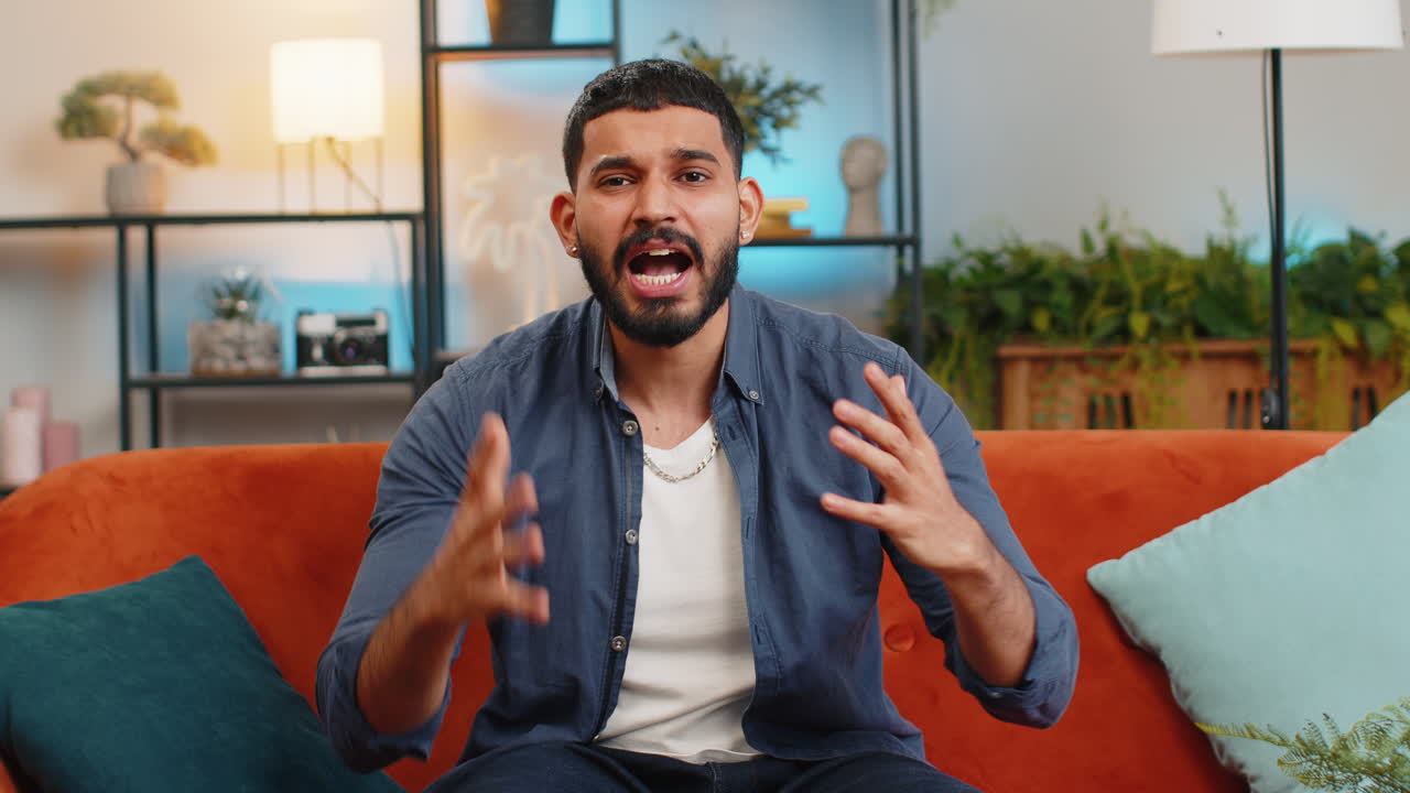 hombre indio molesto mira con rabia agresión regañando protesta luchando a la cámara pelea descontento