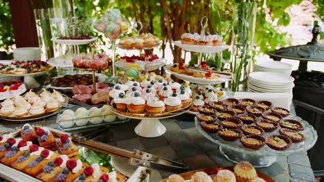 barra de caramelo grande con varios pasteles y pastelitos en la mesa de postres