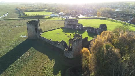 Historical-Flint-castle-medieval-military-ruins-landmark-aerial-view-orbit-right-above-woodland