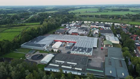 aerial of small industrial terrain with photovoltaic solar panels on rooftop and a small water treatment plant