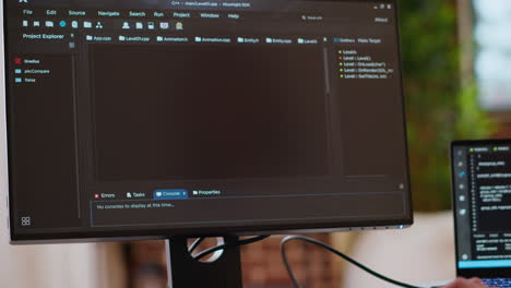 programador asiático visto escribiendo código para un diseño de interfaz de usuario en monitores duales