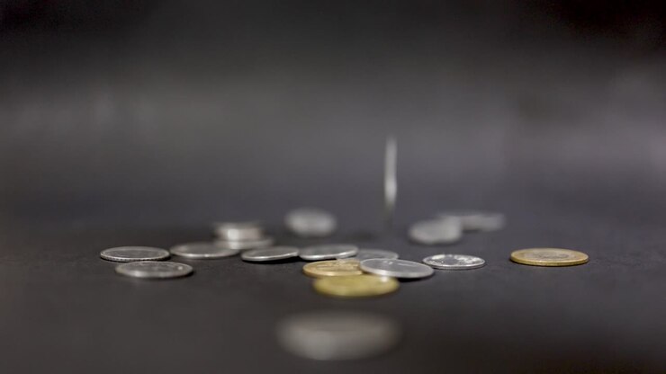 Varietà di monete metalliche sparse che simboleggiano la creazione di ricchezza e il risparmio