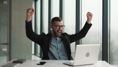 un hombre feliz está lleno de emociones por lo que vio en la computadora portátil