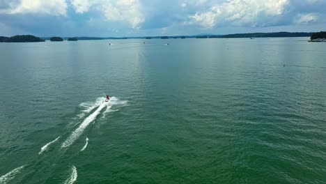 Aerial-tracking-shot-of-jet-ski-running-on-Lake-Lanier-during-cloudy-day,-Georgia