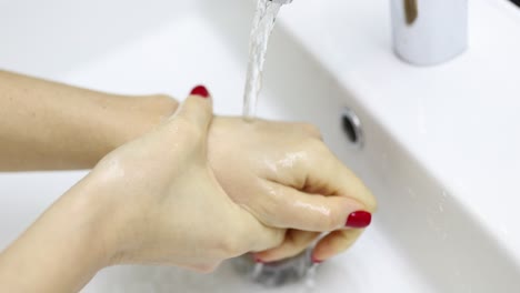 close-up of hands washing under running water in a sink