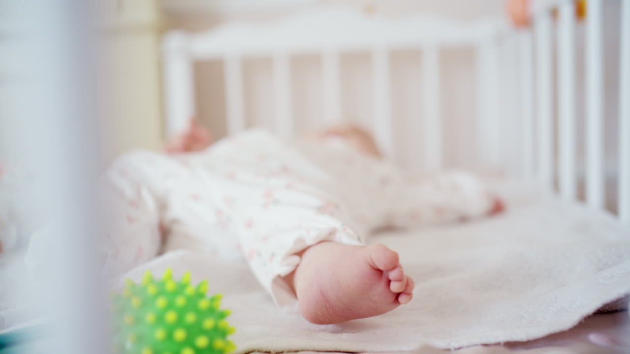 Primo piano dei piedini di un neonato che riposano su una morbida coperta all'interno di una culla