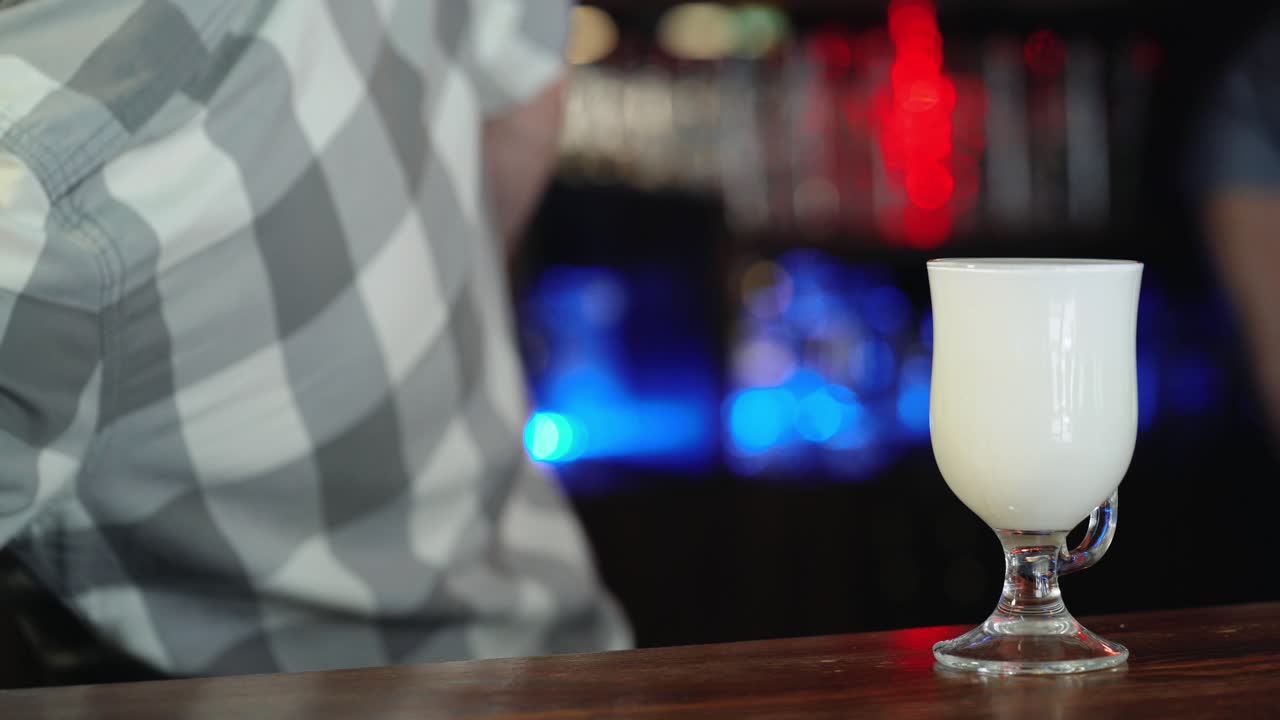 Barista pouring hot milk and coffee to glass. Preparation of Latte Coffee.