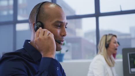 diversas personas de negocios sentadas usando computadoras hablando con auriculares telefónicos