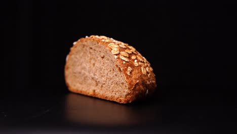 Bread-with-oatmeal-rotates-against-a-black-background