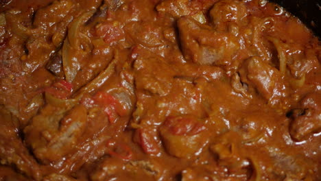 indian beef curry being slow cooked. close up