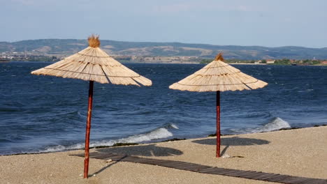 two reed umbrellas on the bank of the river beach