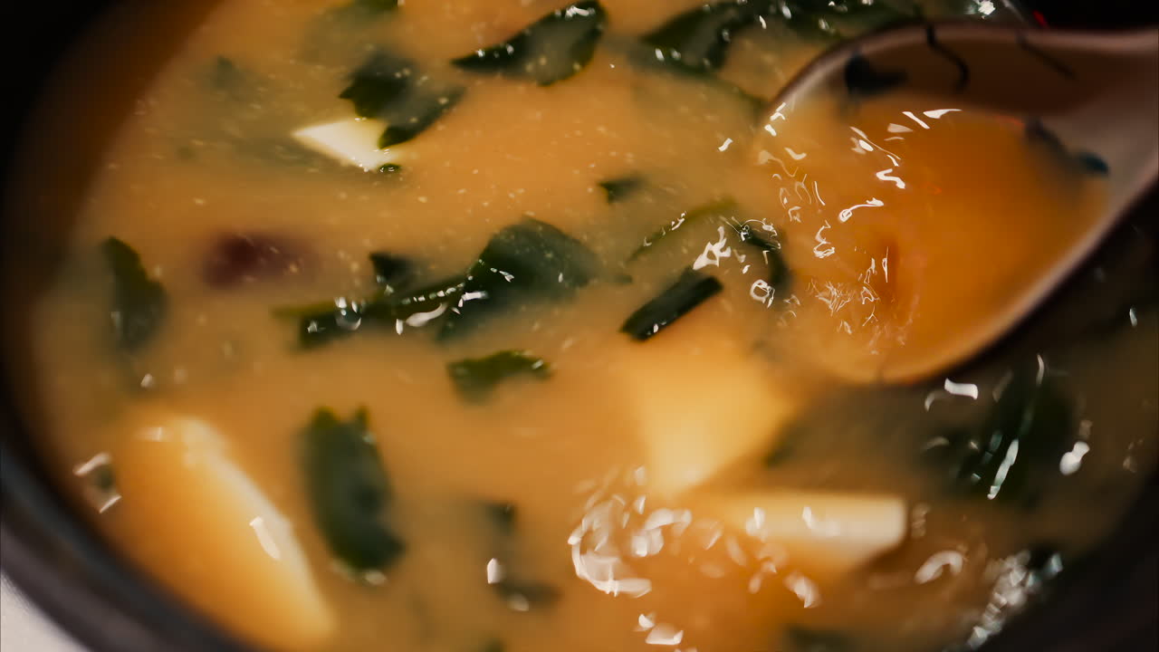 Close up of a woman mixing a miso soup at a restaurant
