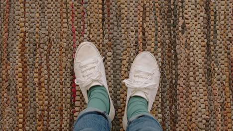 top view woman wearing white shoes enjoying stylish new footware standing on carpet rug