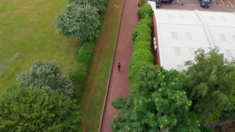 AERIAL-VIEW:-Man-running-through-King-George's-park-in-London-UK