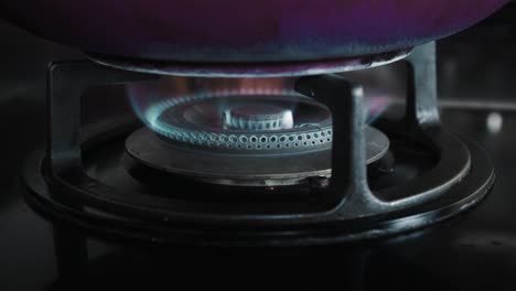 video of a black gas stove with blue and red burning flame in the kitchen