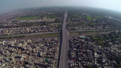 Aerial-view-over-the-Traffic-passes-at-junction-with-canal,-bridge-highway