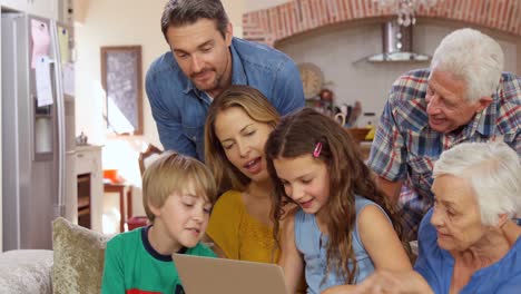 familia de varias generaciones que usa computadora portátil