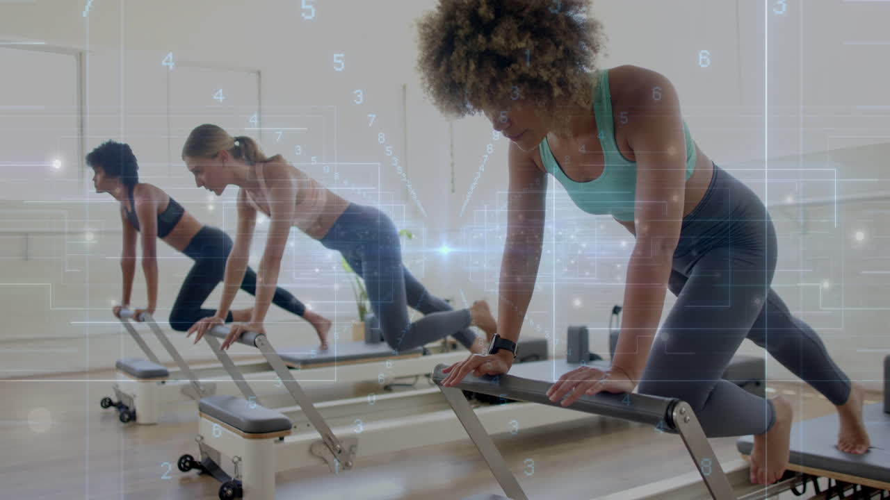 Exercising on reformers, women in fitness studio with animation overlay data
